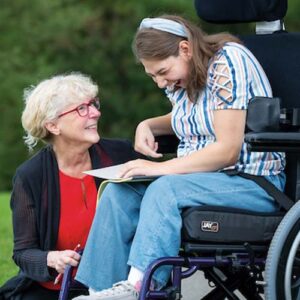 Diane Ryndak interacting with student in wheel chair