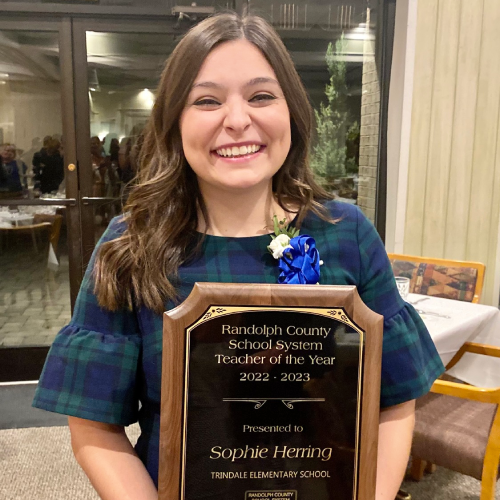 UNCG alumna Sophie Herring holds her 2022-23 Randolph County Teacher of the Year plaque