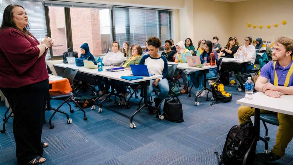 Master's students listen to instructor Dr. Rebecca Matthew at the start of class