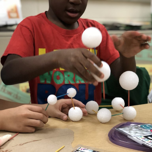 A student builds a model out of styrofoam balls and sticks