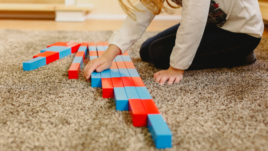 A child on the floor aligns blocks