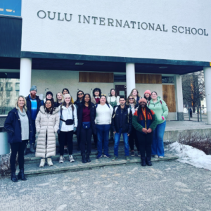 UNCG student teachers stand outside the Oulu International School in Finland