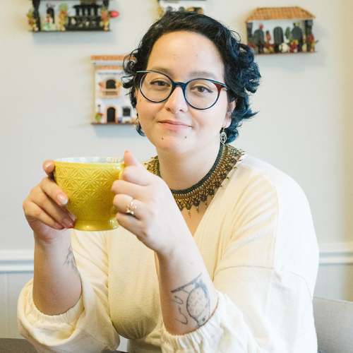 Melissa Carmona holds a coffee mug while sitting in her office
