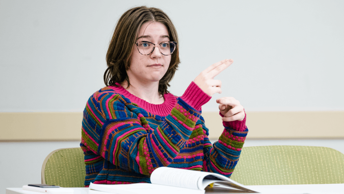 A student utilizes American Sign Language in class