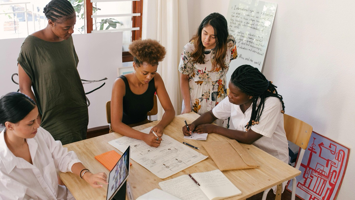 A group of women meet around a table