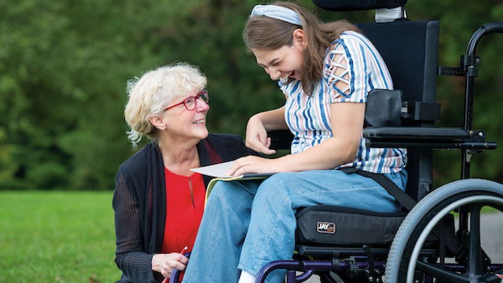 Diane Ryndak interacting with student in wheel chair