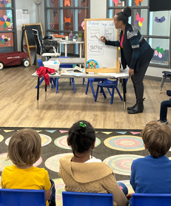 Kindergarten teacher Taryn-Nichelle brainstorms with students about what messages they could put on their protest signs