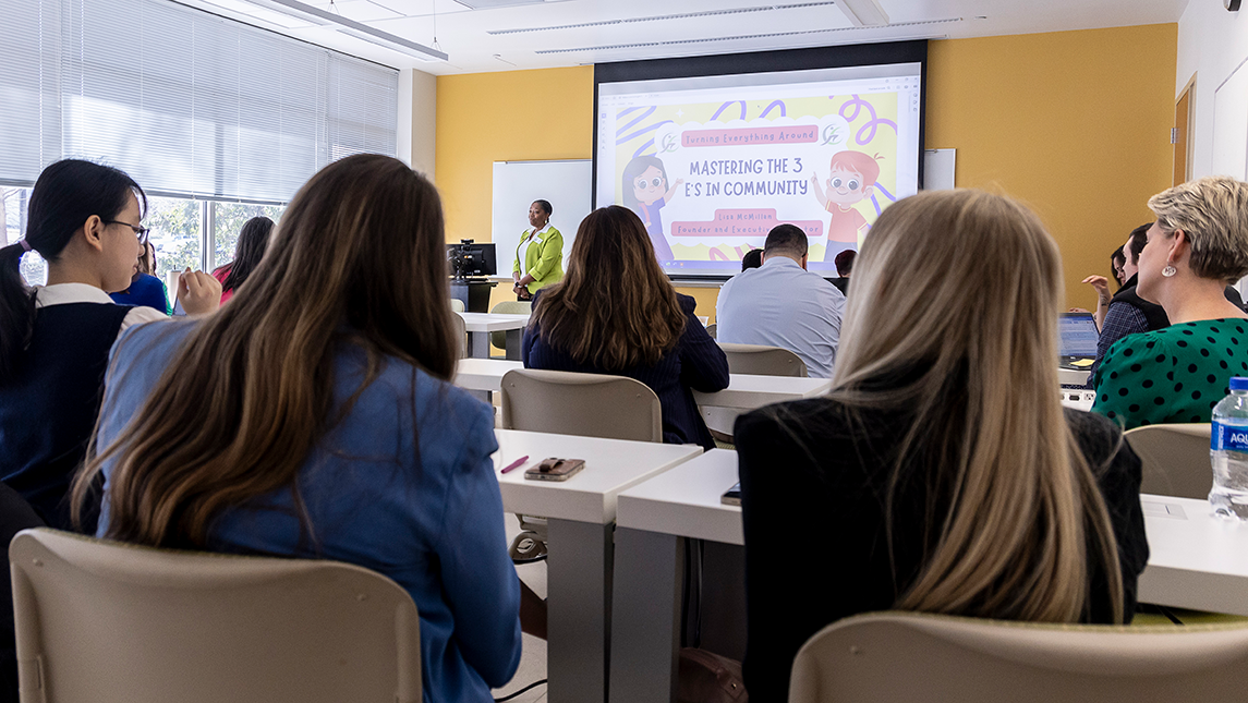 Participants sitting in a room looking at a screen at the front of the room