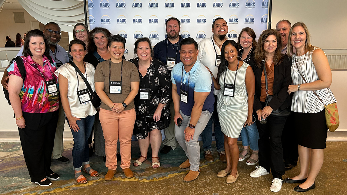 A group of Department of Counseling and Educational Development faculty and alumni gather at a conference