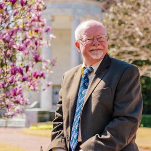 Man sitting outside with a blooming tree