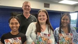 Dr. Holt Wilson (UNCG) meets with three TEACH students following a summer enrichment session, presenting them with their Fall 2025 Mathematics for Teaching textbook as they continue their journey toward becoming future educators.  