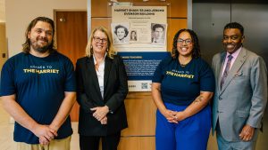 Evenson Scholar Allen Johnson, Betsey Wildhack, Evenson Scholar Cierra Murphy-Higgs ’16 MS, Chancellor Franklin D. Gilliam, Jr. stand beside a plaque honoring Harriet and Jerome Evenson